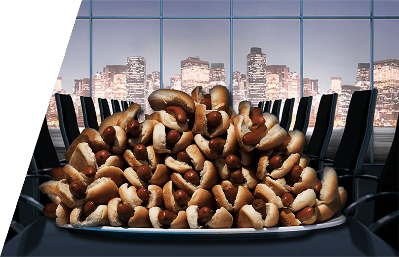 A stacked plate of hotdogs in a boardroom